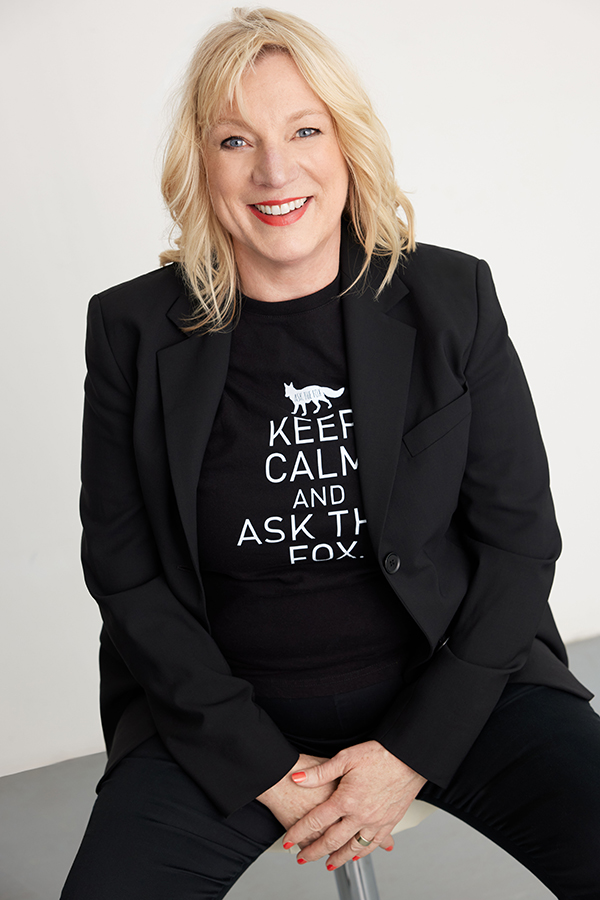 Kerstin Bante im schwarzen Blazer und Shirt mit Fuchs und dem Schriftzug Keep calm and ask the fox