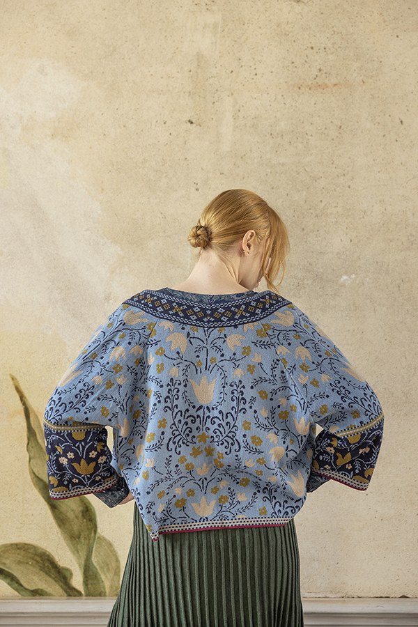 Rückansicht einer blauen Strickjacke mit Blumenmuster