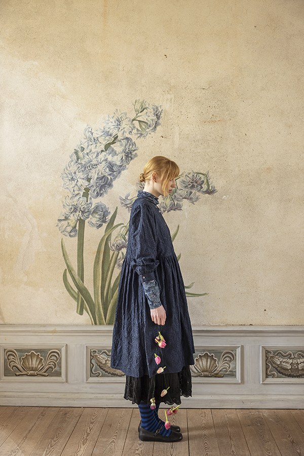 Modell im blauen Kleid vor einer Hyazinthenmalerei