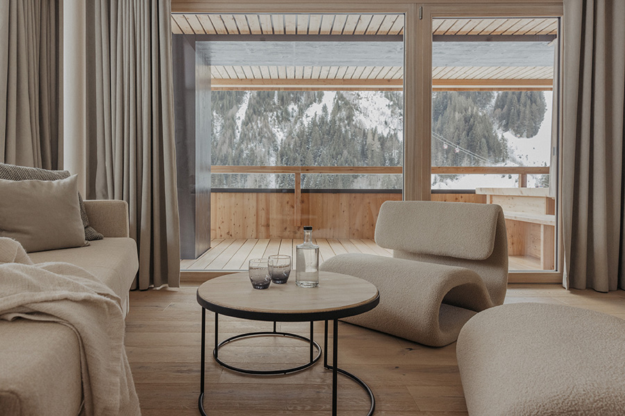 Suite mit Sofa, Sesseln und Blick auf verschneite Berge