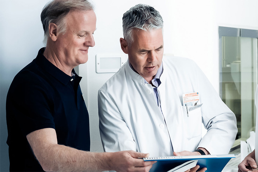 Arzt bespricht Unterlagen mit einem Patienten