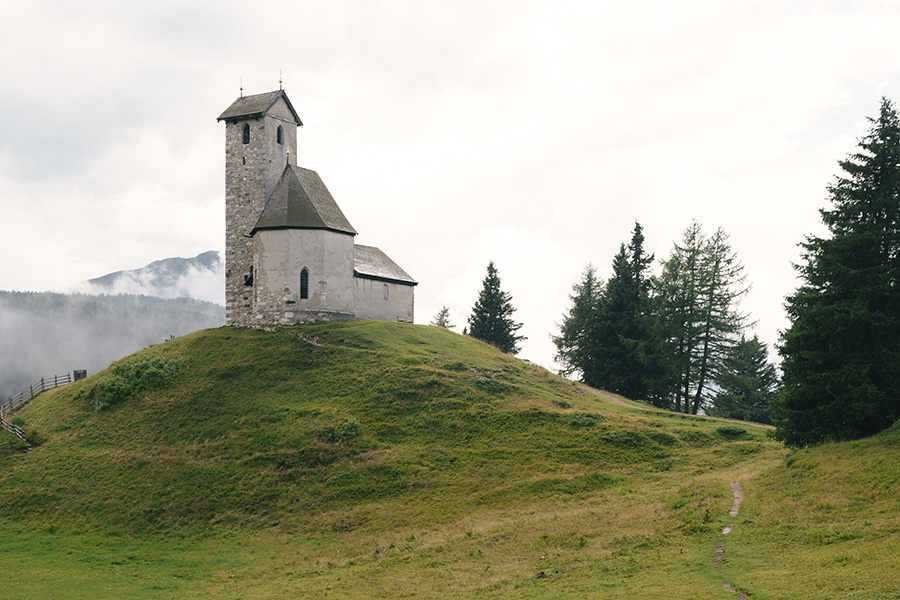 Kleine Kirche auf einem grünen Hügel