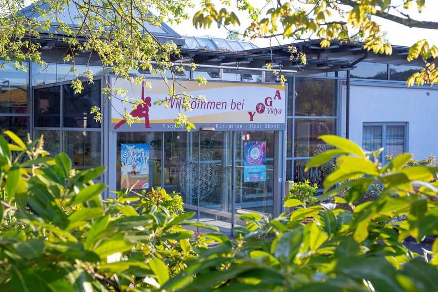 Eingang mit Banner „Willkommen bei Yoga Vidya“